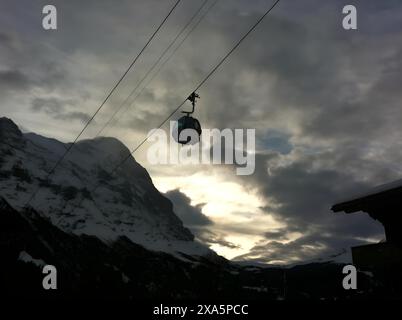 Une photo des Alpes suisses, regardant haut dans le ciel avec une gondole qui monte bien au sommet de la montagne. Prise de Grindelwald, base des montagnes Banque D'Images