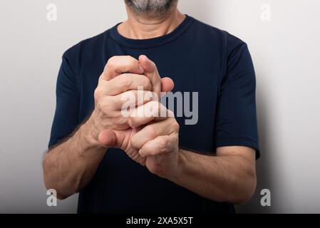 Homme d'âge moyen se grattant le doigt. Maladie de la peau. Réaction allergique. Dermatologie. Isolé sur fond blanc. Banque D'Images