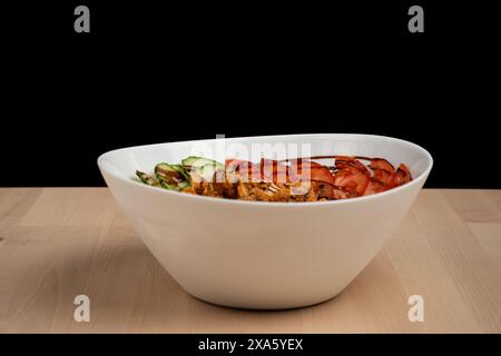Une salade mélangée avec divers ingrédients et de la viande dans un bol Banque D'Images
