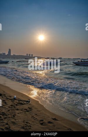 Bateaux amarrés à une plage avec l'horizon de la ville en arrière-plan Banque D'Images