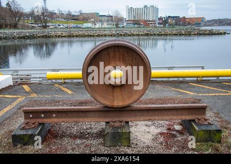 Exposition d'une roue à flasque sur un rail au bord de l'eau à Sydney, Nouvelle-Écosse, Canada Banque D'Images