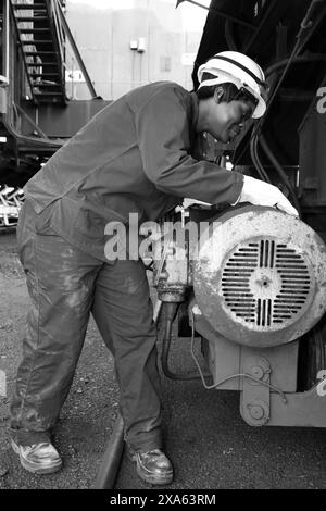 Une technicienne inspectant les machines d'une centrale au charbon de Johannesburg, Afrique du Sud Banque D'Images