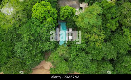 Vue aérienne d'une maison avec piscine couverte de forêt à Sundy Beach Banque D'Images