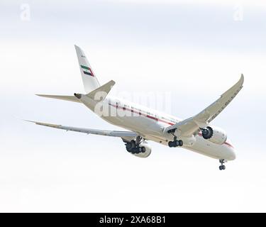 Un avion volant à travers un ciel bleu clair avec des nuages blancs moelleux à Abu Dhabi, eau Banque D'Images