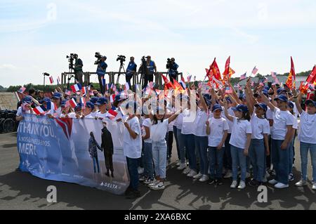 Des écoliers de la communauté normande attendent sur le tarmac pour accueillir les vétérans américains de la seconde Guerre mondiale à l’aéroport de Deauville, France, le 3 juin 2024. Les militaires américains et les membres de la communauté ont accueilli les vétérans qui se sont rendus en France pour participer au 80e anniversaire des célébrations du jour J. La commémoration du jour J 80 sert à honorer les sacrifices consentis il y a 80 ans par les militaires américains pour assurer la paix et la sécurité, et inspirer les générations futures à valoriser une vision collective de la paix mondiale. (Photo de l'armée américaine par le 1er sergent John Etheridge) Banque D'Images