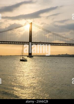 Le pont du 25 avril sur le fleuve Tejo au coucher du soleil à Lisbonne, Portugal Banque D'Images