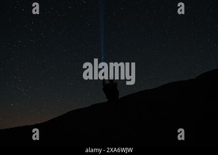 Étoiles brillantes et constellations dans le ciel nocturne la silhouette d'un homme sur le fond du ciel étoilé Un homme brille une lanterne dans le ciel Banque D'Images