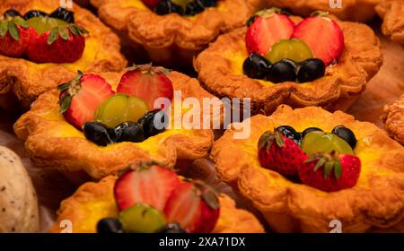 Rangées de pâtisseries garnies de fruits frais Banque D'Images