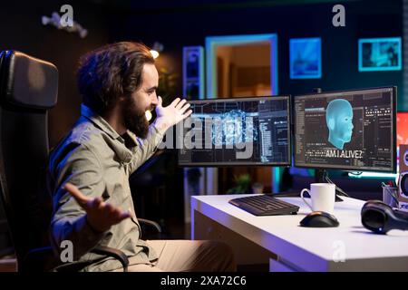 Technicien informatique joyeux célébrant après avoir éveillé une IA sensible posant des questions existentielles. Programmeur extatique enthousiaste à l'idée d'interagir avec l'intelligence artificielle consciente de soi Banque D'Images