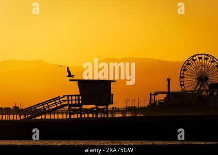 Une vue panoramique sur le coucher du soleil sur les montagnes et un parc d'attractions Banque D'Images