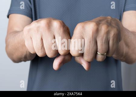 Gros plan des poings d'un homme dans un geste de force Banque D'Images