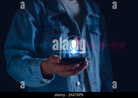 Enregistrement vocal. Homme touchant l'icône du microphone sur le téléphone intelligent. Application mobile enregistrez du son, de l'audio, de la musique, des messages vocaux. Ou utilisez votre voix pour direc Banque D'Images