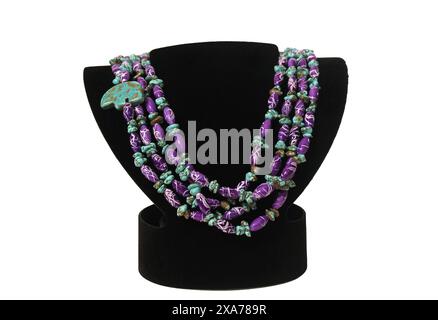 Un gros plan de collier de perles turquoise sur un buste noir sur un fond blanc Banque D'Images