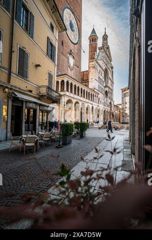 Café avec chaises dans l'allée avec clocher de la cathédrale, Crémone, province de Crémone, Lombardie, Italie, Europe Banque D'Images