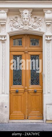 Porte marron avec une sculpture de visage dessus Banque D'Images