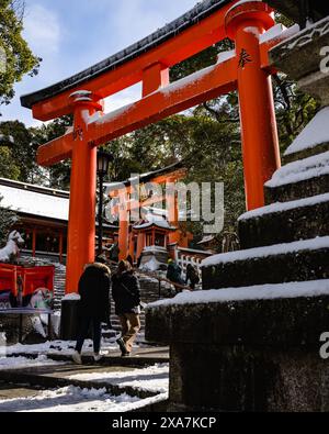 Les adorateurs japonais et les touristes à l'ancienne porte japonaise et les temples couverts de neige rare d'hiver au sanctuaire Fushimi Inari à Kyoto Japon. Banque D'Images