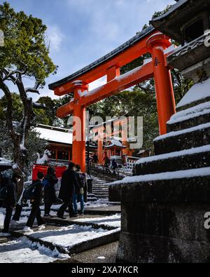 Les adorateurs japonais et les touristes à l'ancienne porte japonaise et les temples couverts de neige rare d'hiver au sanctuaire Fushimi Inari à Kyoto Japon. Banque D'Images