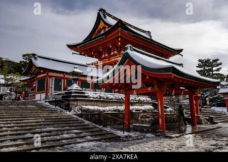 Les adorateurs japonais et les touristes à l'ancienne porte japonaise et les temples couverts de neige rare d'hiver au sanctuaire Fushimi Inari à Kyoto Japon. Banque D'Images