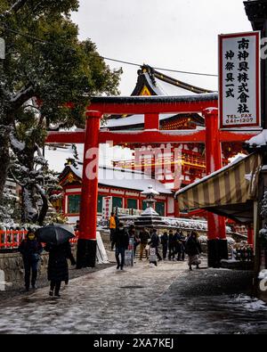 Les adorateurs japonais et les touristes à l'ancienne porte japonaise et les temples couverts de neige rare d'hiver au sanctuaire Fushimi Inari à Kyoto Japon. Banque D'Images
