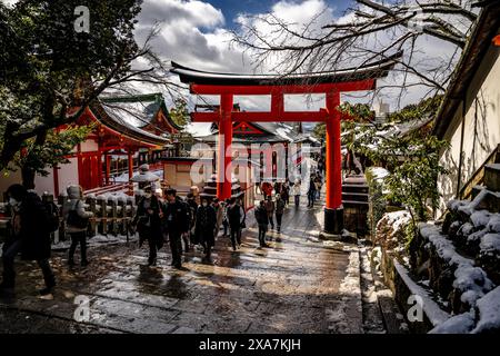 Les adorateurs japonais et les touristes à l'ancienne porte japonaise et les temples couverts de neige rare d'hiver au sanctuaire Fushimi Inari à Kyoto Japon. Banque D'Images