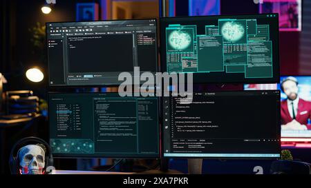 Gros plan sur les lignes de code de piratage dangereuses qui s'exécutent sur les écrans d'ordinateur dans la tanière criminelle. Les scripts de programmation affichés sur les PC s'affichent dans une cachette vide utilisée par les cybercriminels pour voler des données Banque D'Images