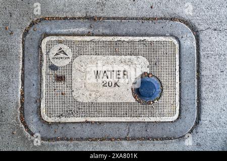 Un couvercle de compteur d'eau en béton Armorcast installé dans le trottoir de la Grande, Oregon, États-Unis Banque D'Images