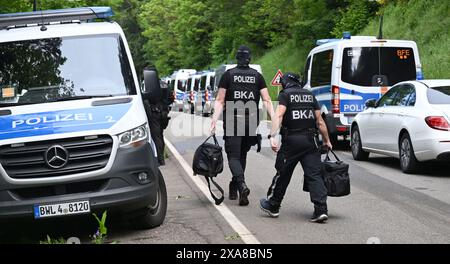 Bad Teinach Zavelstein, Allemagne. 05 juin 2024. Les policiers marchent le long d'une route devant une propriété dans une zone boisée. Un complexe immobilier et une propriété sont fouillés dans le cadre d'un raid contre des partisans présumés d'un groupe Reichsbürger. Crédit : Bernd Weißbrod/dpa/Alamy Live News Banque D'Images