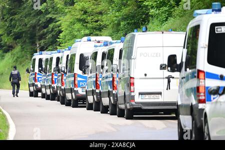 Bad Teinach Zavelstein, Allemagne. 05 juin 2024. Les véhicules de police sont stationnés sur une route devant une propriété dans une zone boisée. Un complexe immobilier et une propriété sont en cours de fouille dans le cadre d'un raid contre des partisans présumés d'un groupe Reichsbürger. Crédit : Bernd Weißbrod/dpa/Alamy Live News Banque D'Images