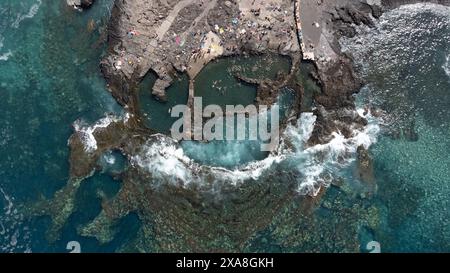 Vue d'en haut des piscines naturelles d'Agaete dans le nord de Gran Canaria. Des gens méconnaissables appréciant les piscines creusées dans la roche volcanique, entourent Banque D'Images