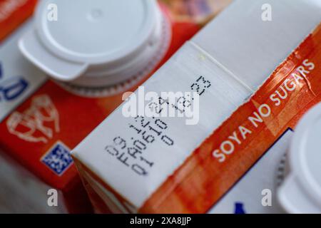 Gros plan d'une boîte de lait de soja, montrant spécifiquement la date limite de consommation et l'heure imprimées sur l'emballage. L'image met en évidence des informations sur la sécurité alimentaire et la durée de conservation des alternatives laitières à base de plantes, soulignant l'importance de consommer les produits avant leur expiration pour l'assurance de la santé et de la qualité Banque D'Images