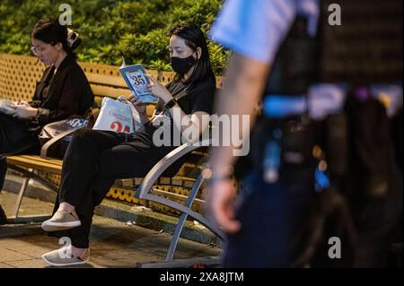 Hong Kong, Chine. 04 juin 2024. Une femme lit "35 mai" sur un banc à Victoria Park comme une veillée personnelle à ceux qui ont perdu la vie il y a 35 ans. La police était en force sur le site traditionnel d'un service commémoratif pour ceux qui ont perdu la vie pendant la répression du gouvernement chinois sur la place Tiananmen le 4 juin 1989. La police a arrêté, fouillé et expulsé plusieurs personnes qui tentaient de commémorer l'événement. (Photo de Ben Marans/SOPA images/SIPA USA) crédit : SIPA USA/Alamy Live News Banque D'Images