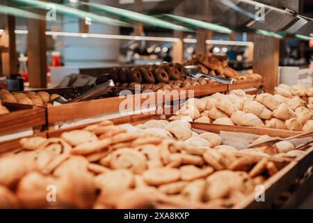 Assortiment de pâtisseries sur plateaux en bois avec leurs pinces individuelles placées côte à côte dans un buffet d'hôtel. Banque D'Images