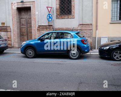 Cremona, Italie - 27 mai 2024 Fiat 500 x 4x4 voiture bleue vibrante garée dans un terrain payant sur une charmante rue italienne, ajoutant l'agitation urbaine. Fiat se distingue aga Banque D'Images