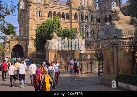 Passants et touristes occidentaux en dehors de l'emblématique Chhatrapati Shivaji Maharaj Terminus de l'époque coloniale à Mumbai, en Inde, un bâtiment classé au patrimoine de l'UNESCO Banque D'Images