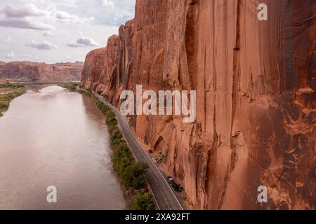 Vue aérienne des falaises de Wingate le long de l'autoroute 279 le long du fleuve Colorado près de Moab, Utah. Notez les véhicules garés des grimpeurs le long de Wall St. Banque D'Images