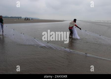 5 juin 2024, Cox's Bazar, Chittagong, Bangladesh : les pêcheurs capturent des poissons avec des filets de pêche à Cox's Bazar Sea Beach, Bangladesh. Le gagne-pain de la communauté des pêcheurs ici dépend largement de la pêche. Cox's Bazar, la plus longue plage marine naturelle du monde, s'étend sur plus de 120 kilomètres le long de la côte sud-est du Bangladesh. Réputée pour son sable doré, ses couchers de soleil vibrants et ses vagues, elle attire des millions de touristes chaque année. (Crédit image : © Joy Saha/ZUMA Press Wire) USAGE ÉDITORIAL SEULEMENT! Non destiné à UN USAGE commercial ! Banque D'Images