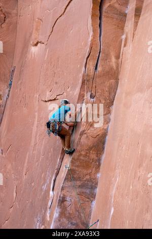 Un grimpeur en tête grimpe à Wall Street, près de Moab, Utah. Banque D'Images