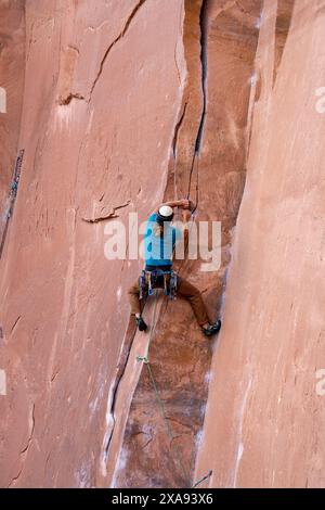 Un grimpeur en tête grimpe à Wall Street, près de Moab, Utah. Banque D'Images