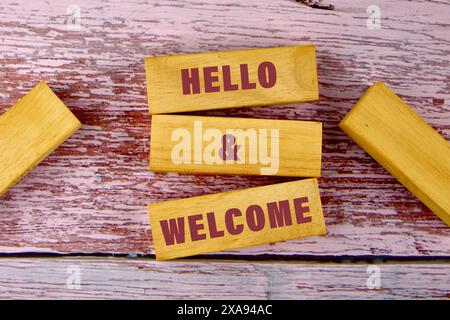 Symbole commercial conceptuel. Copier l'espace. Bonjour et mots de bienvenue écrit une phrase conceptuelle sur des blocs de bois reposant sur de vieilles planches Banque D'Images