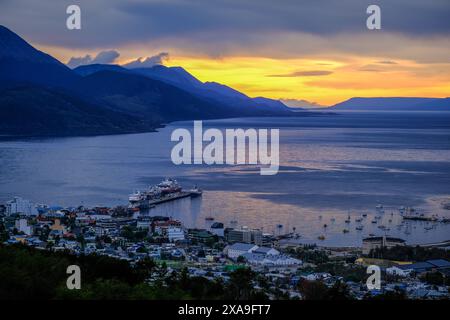 Ushuaia, Feuerland, Argentinien - Sonnenaufgang ueber dem Beagle-Kanal, der Beagle-Kanal ist eine natuerliche Wasserstrasse an der Suedspitze Suedamerikas, die den Atlantik mit dem Pazifik verbindet. Ushuaia ist die suedlichste Stadt der Welt, das Ende der Welt. Hinten Bergkette auf der Insel Navarino au Chili, Dientes de Navarino. Ushuaia Feuerland Argentinien *** Ushuaia, Terre de feu, Argentine lever du soleil sur le canal Beagle, le canal Beagle est une voie navigable naturelle à la pointe sud de l'Amérique du Sud qui relie l'océan Atlantique à l'océan Pacifique Ushuaia est la plus méridionale Banque D'Images