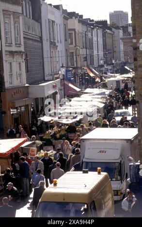 Samedi touristes visitant et londoniens marchant vers le haut et vers le bas Portobello Road, vue sur la rue sur les étals du marché de chaque côté de la route, vendant des antiquités et des trucs bon marché. (En regardant vers le nord) Notting Hill West London 1990s 90s UK HOMER SYKES Banque D'Images