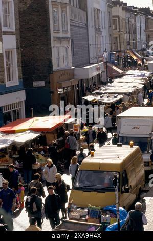 Samedi touristes visitant et londoniens marchant vers le haut et vers le bas Portobello Road, vue sur la rue sur les étals du marché de chaque côté de la route, vendant des antiquités et des trucs bon marché. (En regardant vers le nord) Notting Hill West London 1990s 90s UK HOMER SYKES Banque D'Images