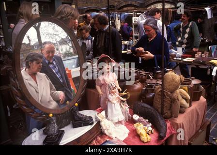 Street Market London. Golborne Road extrémité nord de Portobello Road. Samedi marché traditionnel des antiquités et des briques à chauve-souris. Couple regardant réfléchi dans le miroir. Années 1990 Royaume-Uni 1999. Golborne Road est l'endroit où une grande partie du film Notting Hill a été tourné sur place. HOMER SYKES Banque D'Images