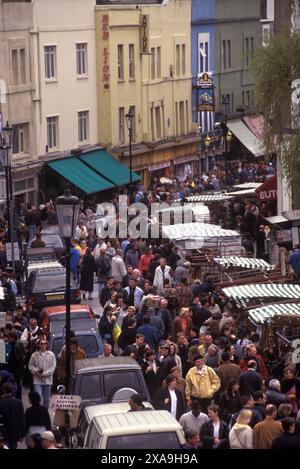 Samedi touristes visitant et londoniens marchant vers le haut et vers le bas Portobello Road, vue sur la rue sur les étals du marché de chaque côté de la route, vendant des antiquités et des trucs bon marché. (En regardant vers le nord) Notting Hill West London 1990s 90s UK HOMER SYKES Banque D'Images