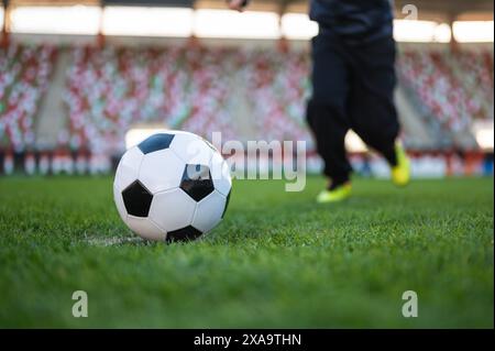 Ballon de football et jambes du jeune joueur avant de frapper le ballon Banque D'Images