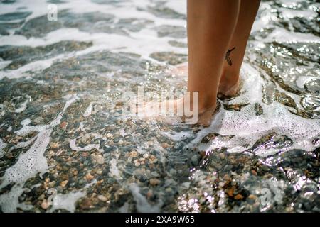 Les pieds d'une personne immergés dans l'eau Banque D'Images