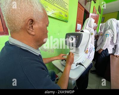 klaten, indonésie mai- 2023 volontaires effectuent des examens de santé oculaire gratuits dans les écoles de madrasah islamique, en utilisant du matériel autoréfracteur. ophth Banque D'Images