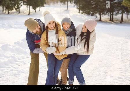 Famille heureuse avec des enfants debout à l'extérieur profitant de la belle nature dans la forêt d'hiver. Banque D'Images