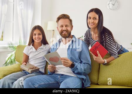 Portrait de l'homme qui a reçu des félicitations et des cadeaux de sa fille et épouse aimantes. Banque D'Images