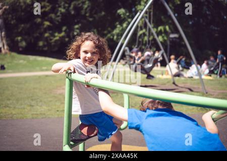 fille de 5 ans jouant sur le rond-point dans le parc ensoleillé Banque D'Images